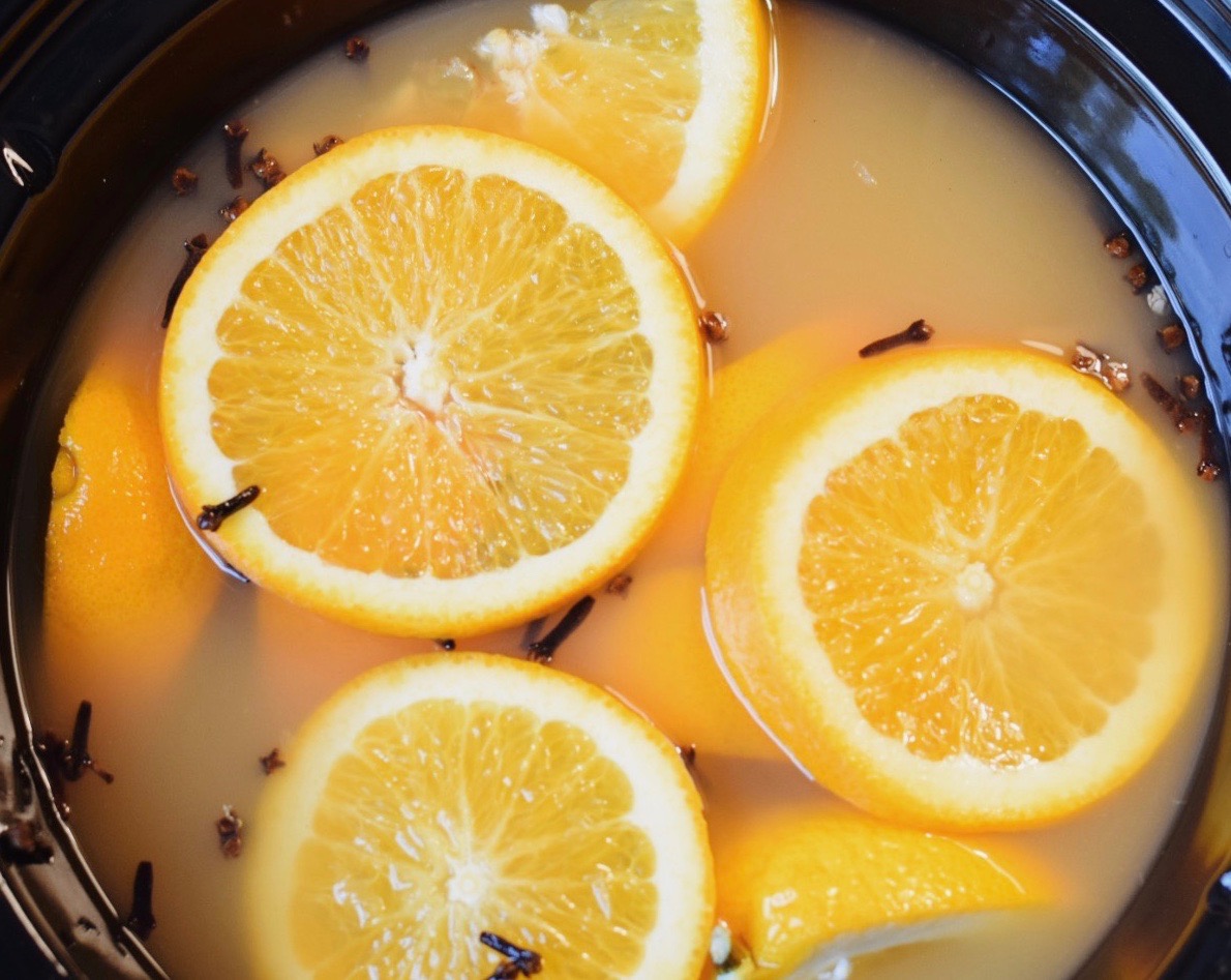spiked mulled apple cider and oranges in a crockpot 